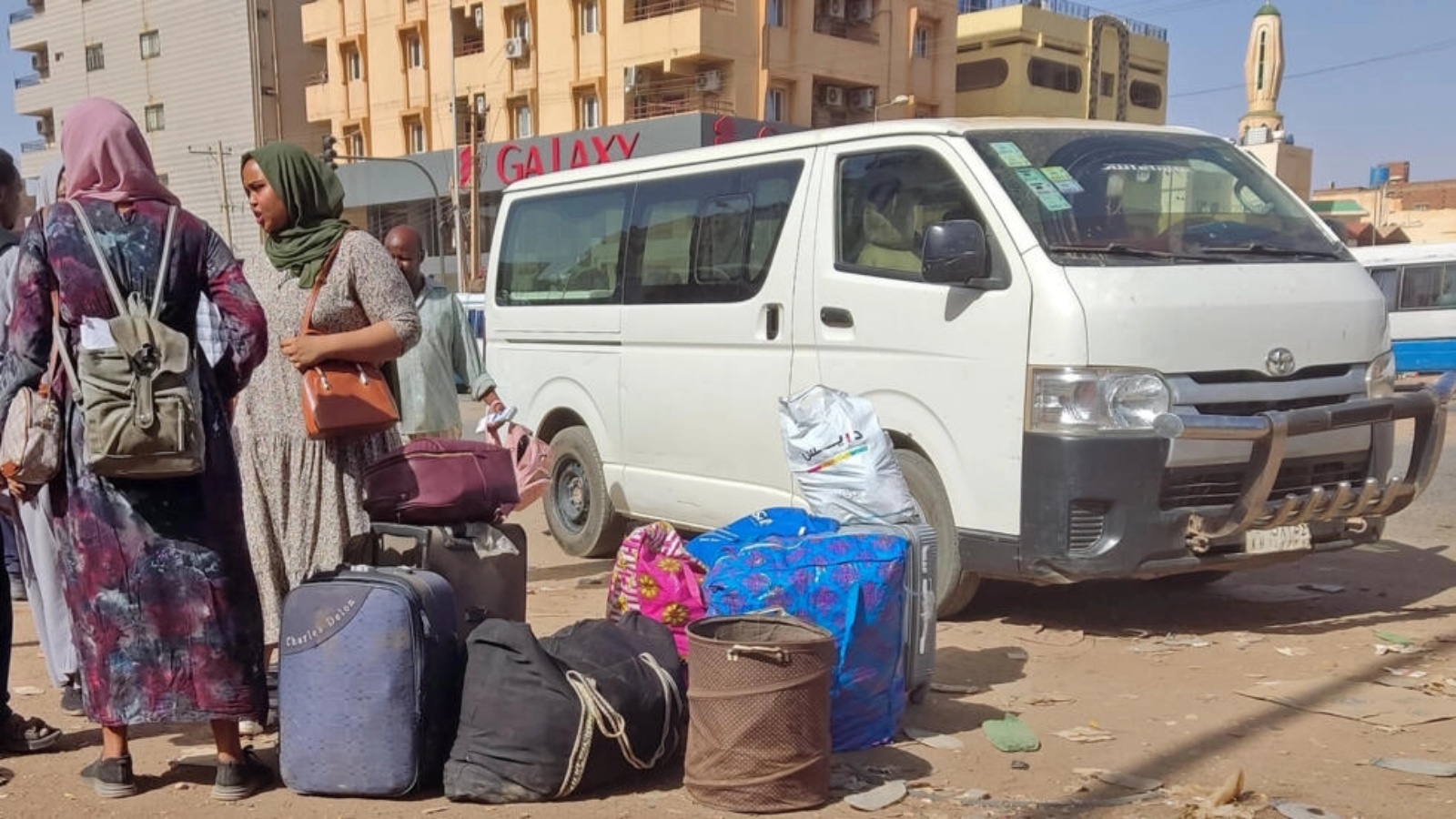 سودانيون ينتظرون مع حقائبهم في محطة حافلات في جنوب الخرطوم في الثامن من ايار/مايو 2023 مع تواصل القتال بين الجيش وقوات الدعم السريع