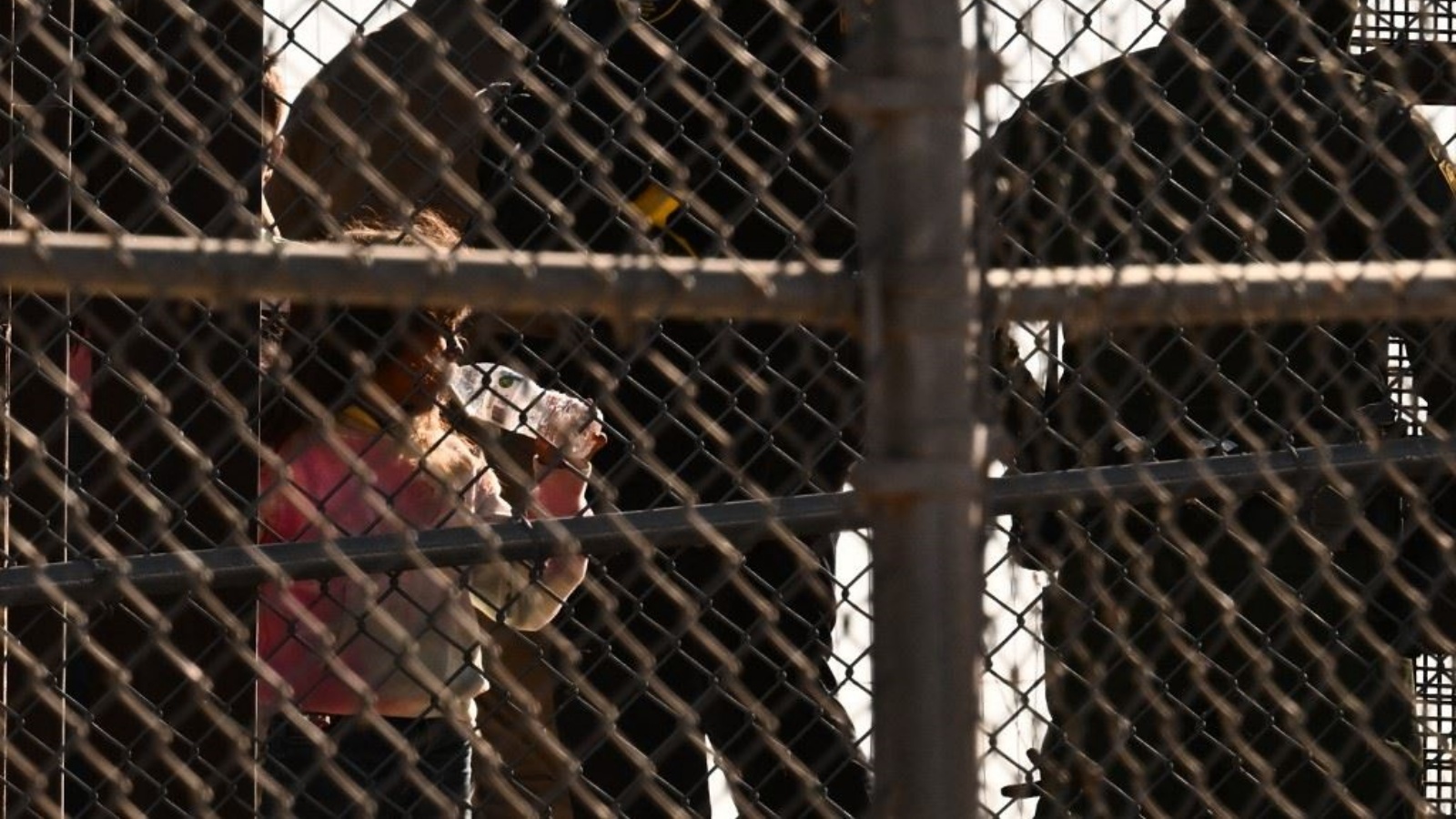طفل يشرب من زجاجة ماء على الحدود بين الولايات المتحدة والمكسيك 