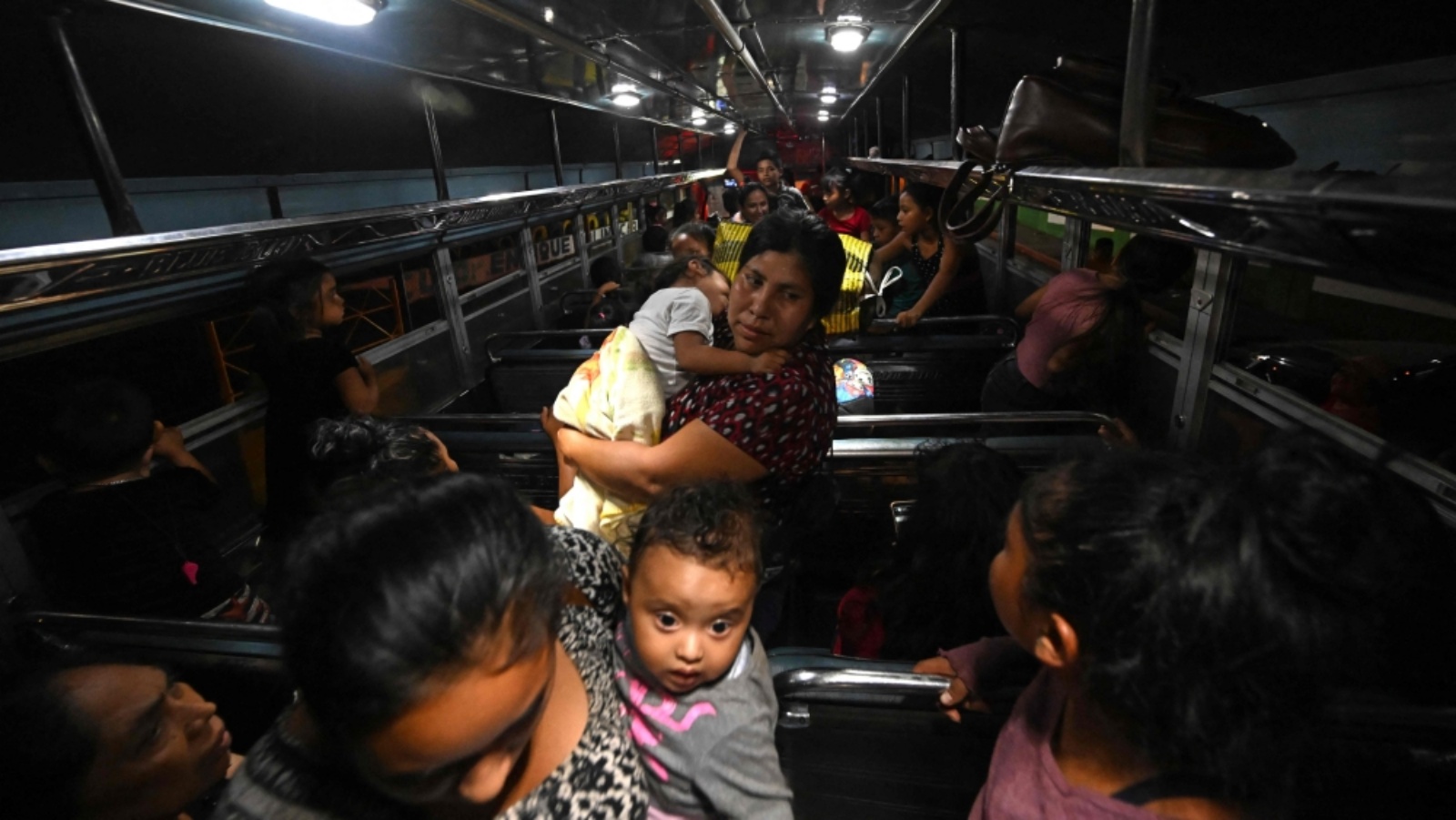 أشخاص يتجهون بالحافلة إلى ملجأ في مركز رياضي بعد الفرار من قريتهم المتضررة من بركان فويغو في سانتا لوسيا كوتزومالغوابا ، إسكوينتلا جنوب مدينة غواتيمالا، في 4 مايو 2023.