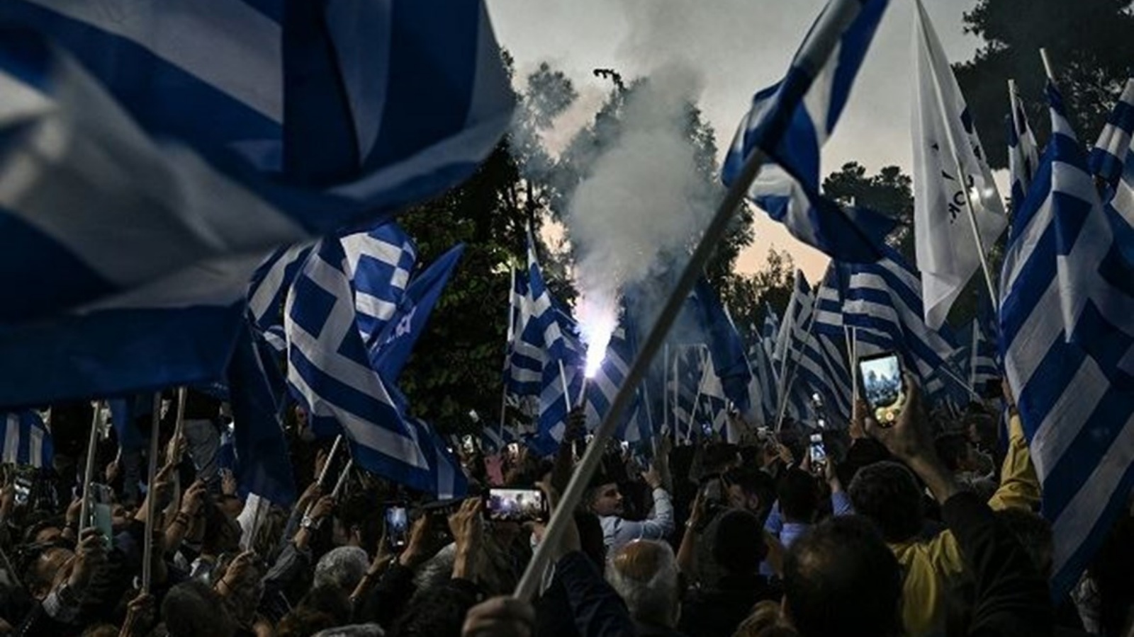 أنصار رئيس الوزراء اليوناني الحالي وزعيم حزب الديموقراطية الجديدة المحافظ يلوحون بالأعلام اليونانية