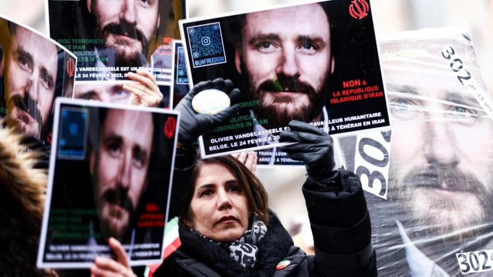 متظاهرون يرفعون لافتات يوم 22 يناير 2023 في بروكسل للمطالبة بالإفراج عن العامل الإنساني البلجيكي أوليفييه فانديكاستيل المسجون في إيران