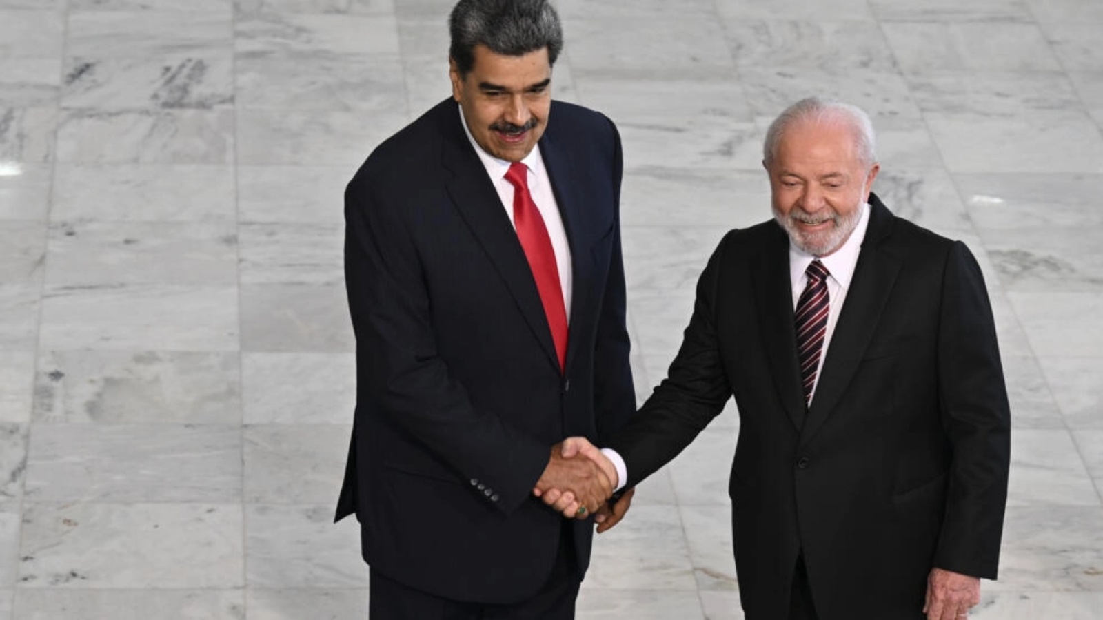 الرئيس الفنزويلي نيكولاس مادورو (إلى اليسار) والرئيس البرازيلي لويس إيناسيو لولا دا سيلفا يتصافحان خلال حفل ترحيب في القصر الرئاسي في برازيليا