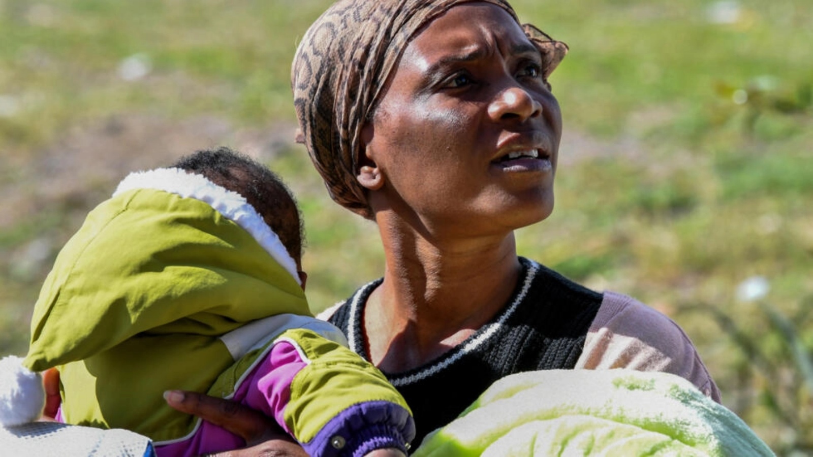 مهاجرة من دول أفريقيا جنوب الصحراء تحمل ابنها وتجلس أمام سفارة ساحل العاج في العاصمة التونسية في 27 فبراير 2023