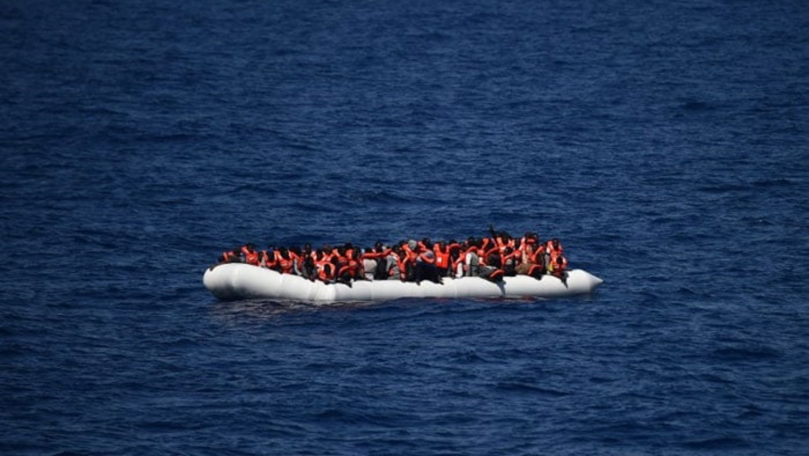 لاجئون ينتظرون على قارب مطاطي ليتم إنقاذهم خلال عملية في البحر