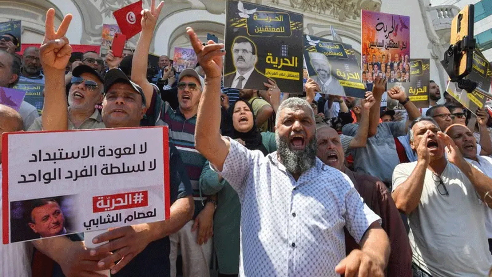 متظاهرون يرفعون لافتات تطالب بالإفراج عن سجناء سياسيين خلال تجمّع دعا إليه تحالف جبهة الإنقاذ الوطني المعارض في تونس العاصمة في 18 حزيران\يونيو 2023