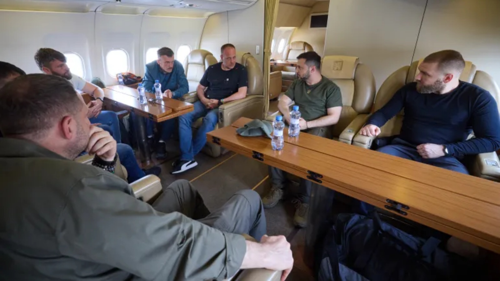 زيلينسكي (الثاني من اليمين) يتحدث إلى قادة كتيبة آزوف الذي رافقوه على متن الطائرة إلى أوكرانيا