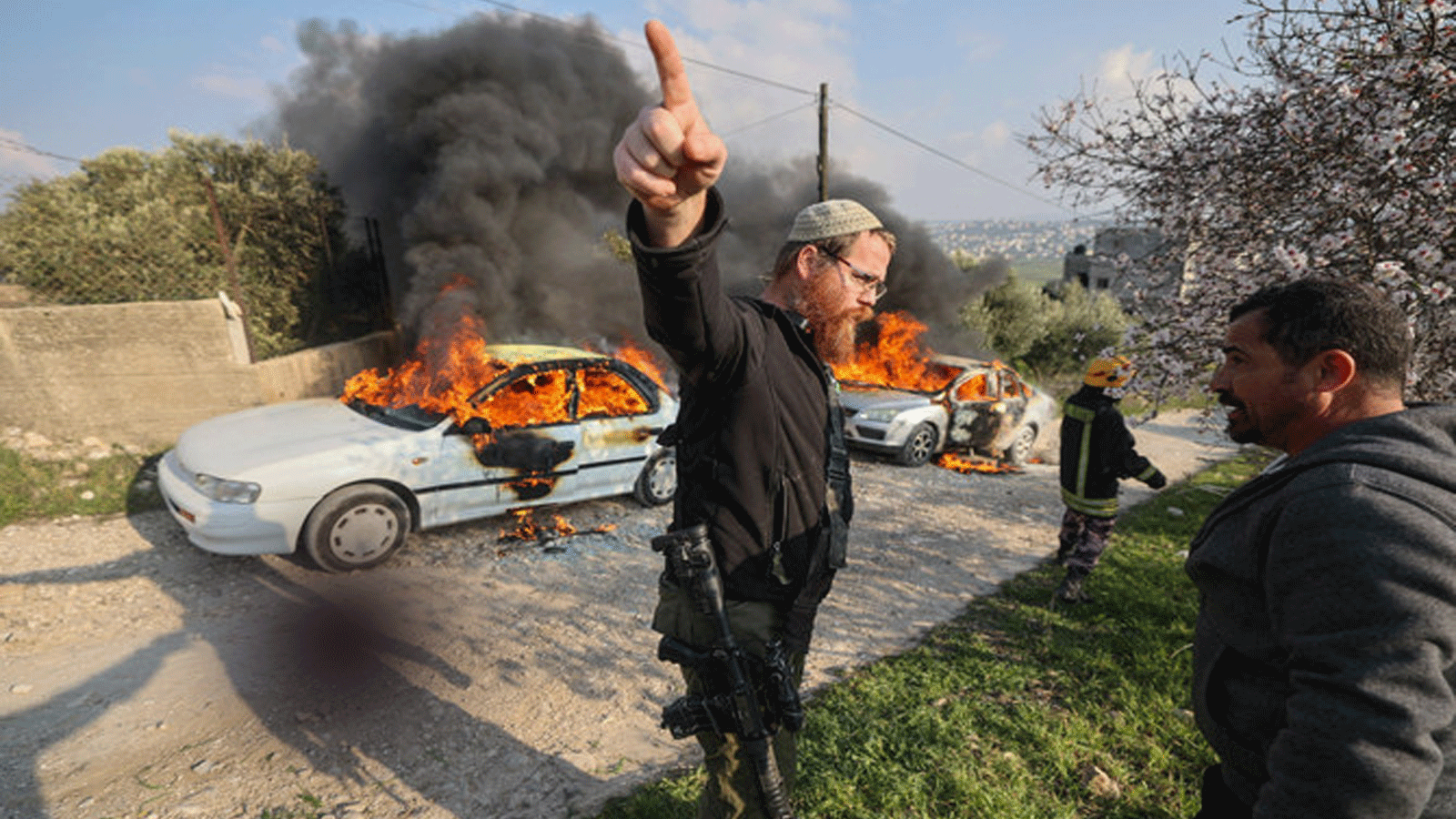 إسرائيليون مسلحون وسط اشتباكات بين مستوطنين وفلسطينيين في قرية بورين، بعد ورود أنباء عن قيام مستوطنين بإضرام النار في سيارات القرية. صورة التُقِطَت بتاريخ 25 شباط\ فبراير 2023
