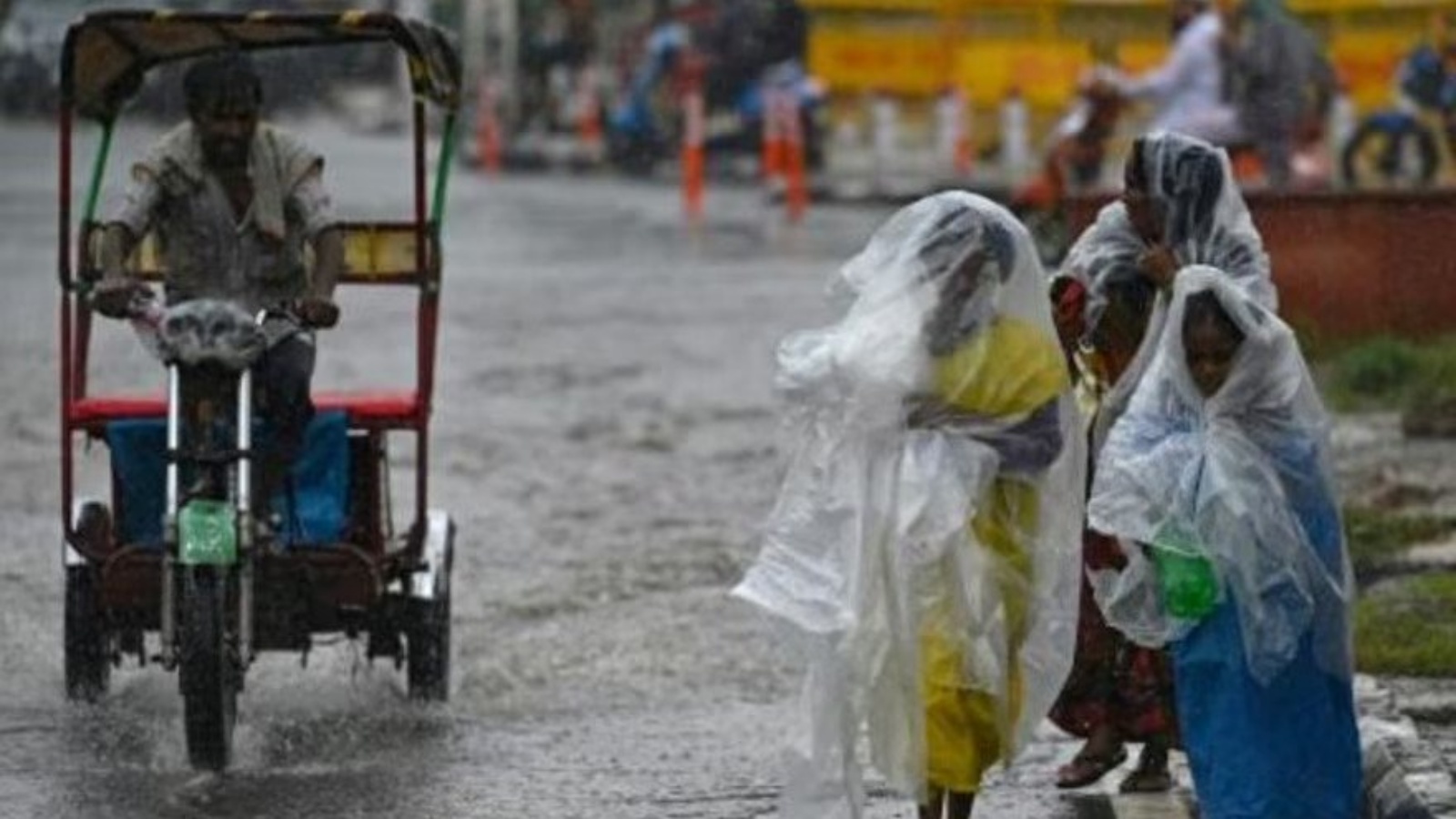 عابرون يستخدمون الأغطية البلاستيكية لحماية أنفسهم من الأمطار في نيودلهي في 10 يوليو 2023
