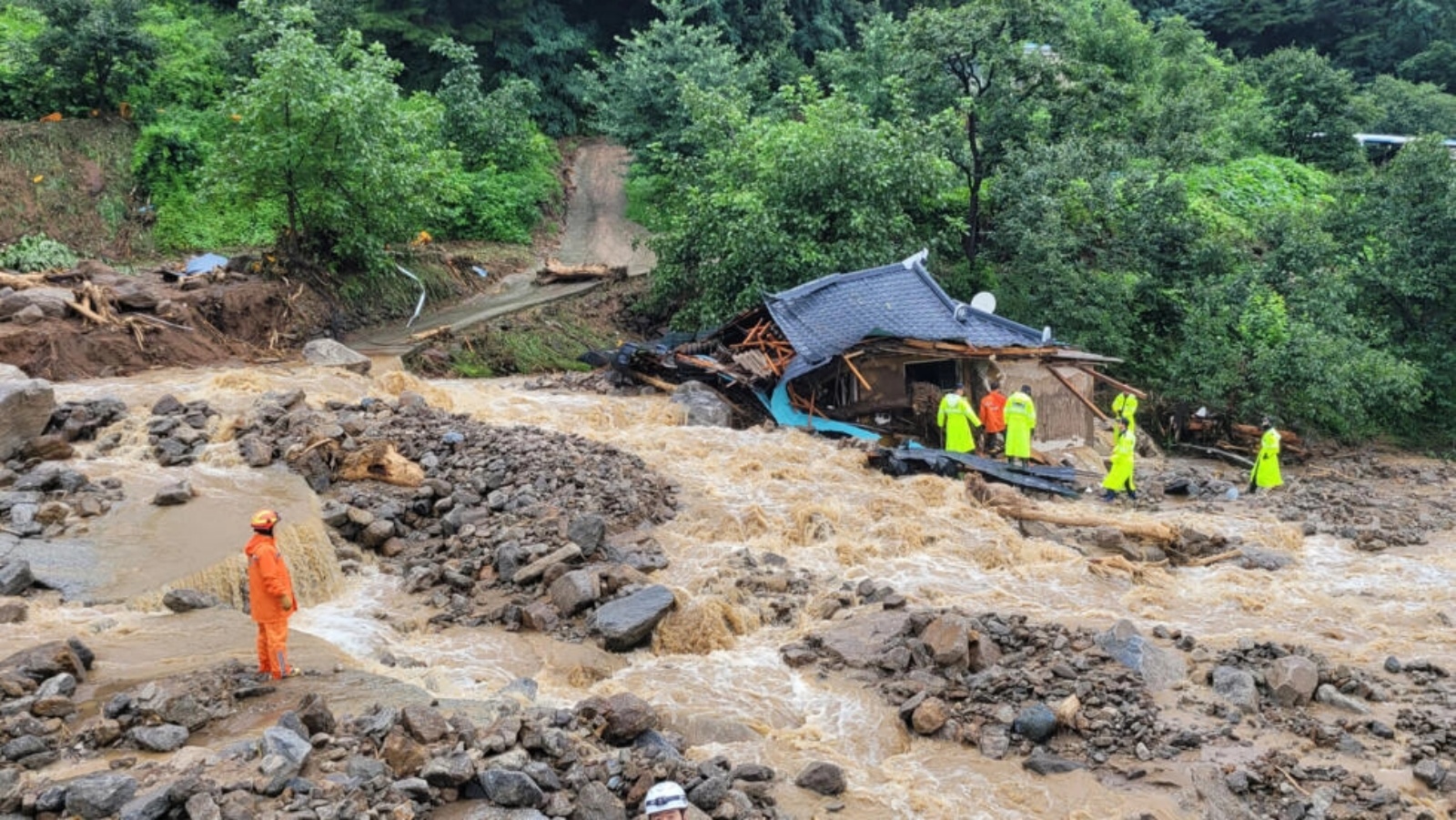 عمال الإنقاذ يبحثون عن ناجين في منزل دمرته الفيضانات بعد هطول أمطار غزيرة في يتشيون في كوريا الجنوبية في 15 يوليو 2023