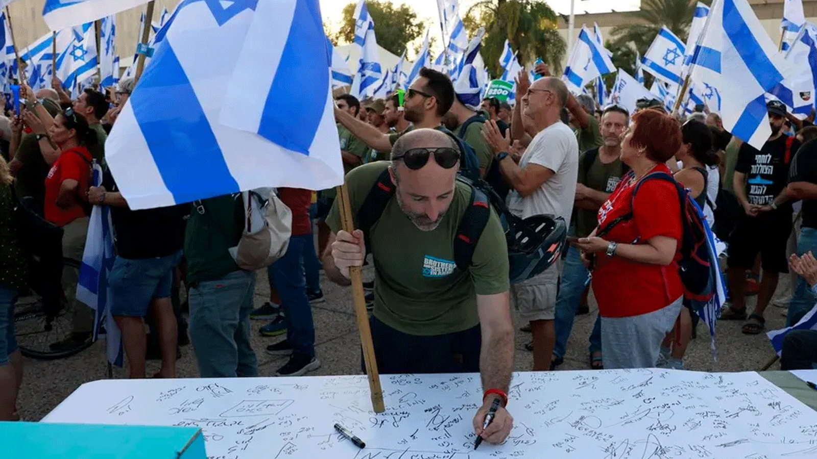 جندي احتياطي إسرائيلي يوقع إعلانًا يُعلنِ فيه تعليق خدمته الاحتياطية الطوعية احتجاجا على مشروع قانون الإصلاح القضائي للحكومة في تل أبيب. 19 تموز\يوليو 2023