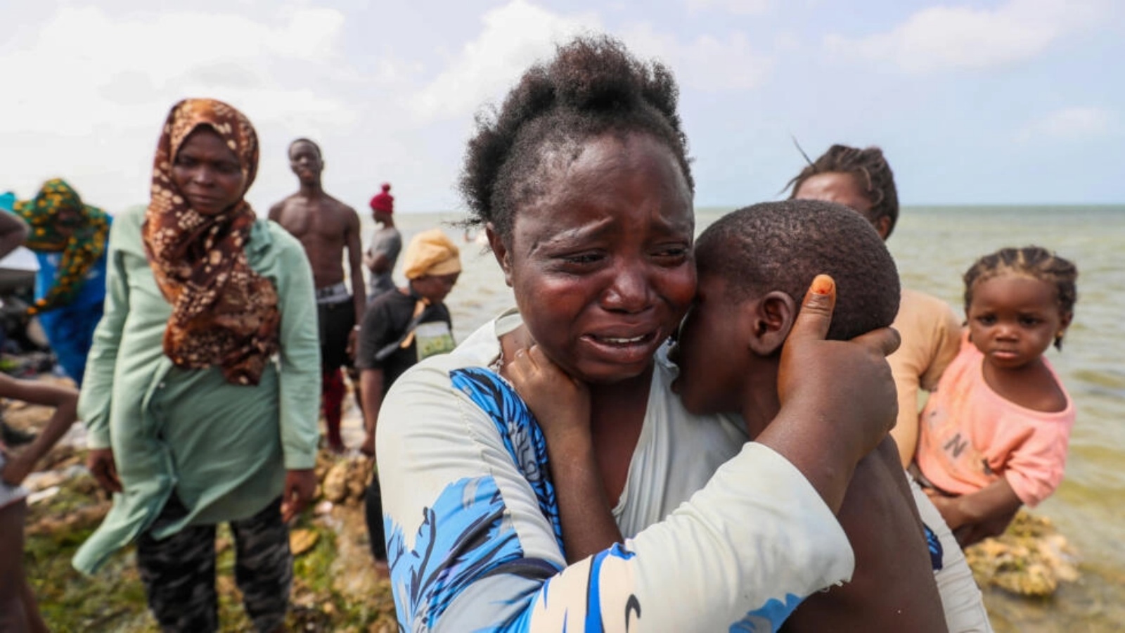 مهاجرة إفريقية تبكي وهي تحمل ابنها في رأس جدير عند الحدود بين ليبيا وتونس في 26 يوليو 2023 