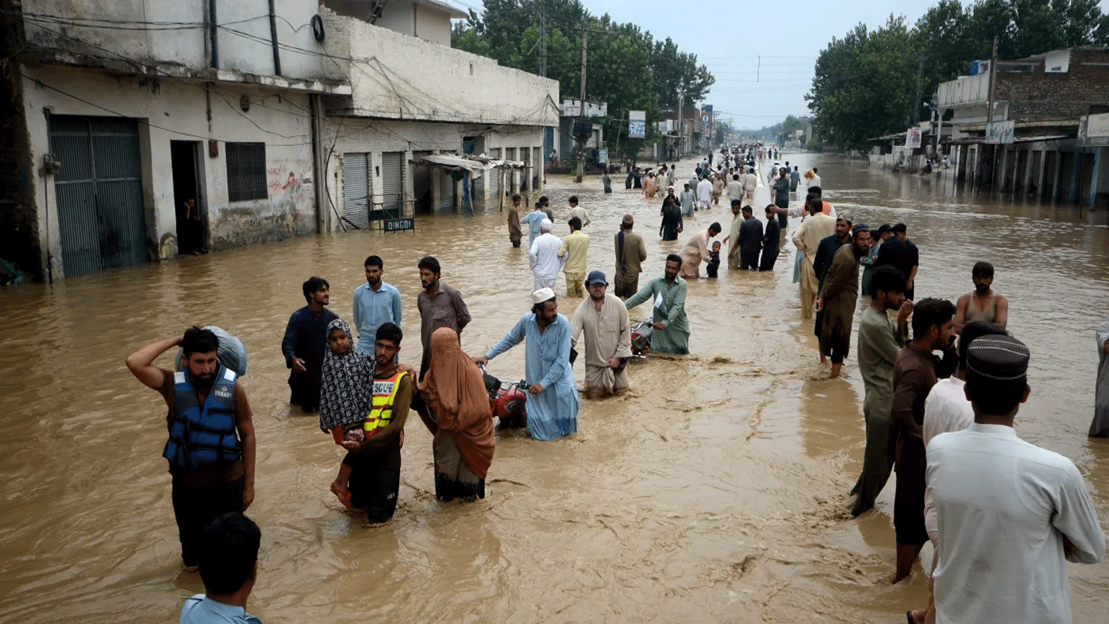نازحون يتجولون في منطقة غمرتها المياه في بيشاور، خيبر باختونخوا، باكستان