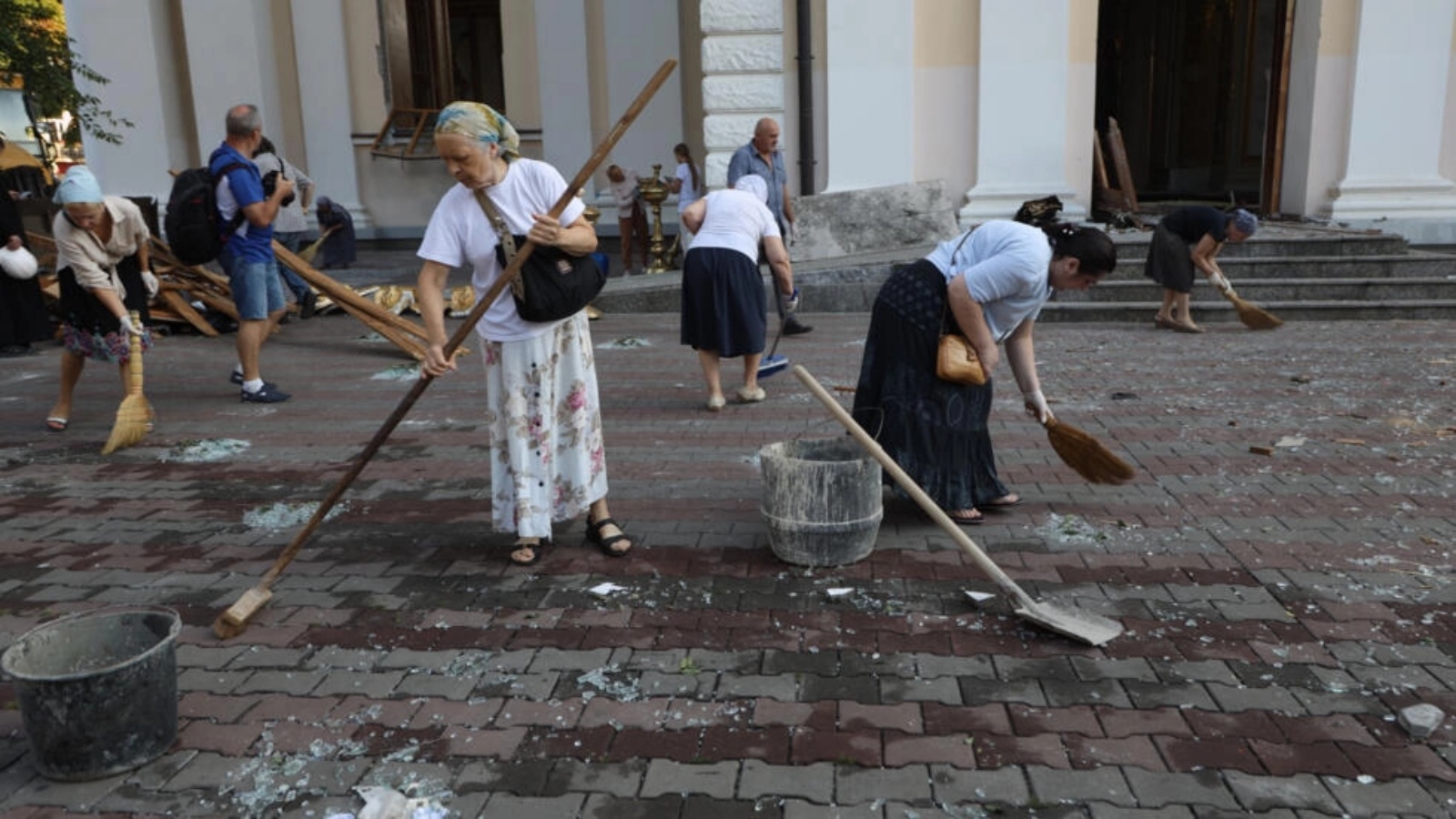 سكان ينظفون منقطة تضررت نتيجة قصف روسي في أوديسا بتاريخ 23 يوليو 2023