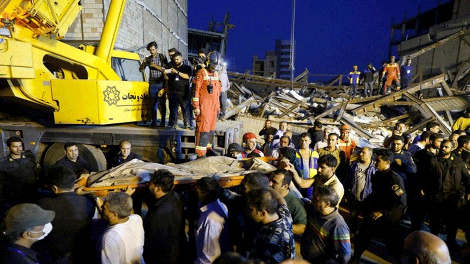 أفراد الإنقاذ ينتشلون جثة الضحية من تحت أنقاض مبنى منهار في طهران في 6 أغسطس\آب 2023