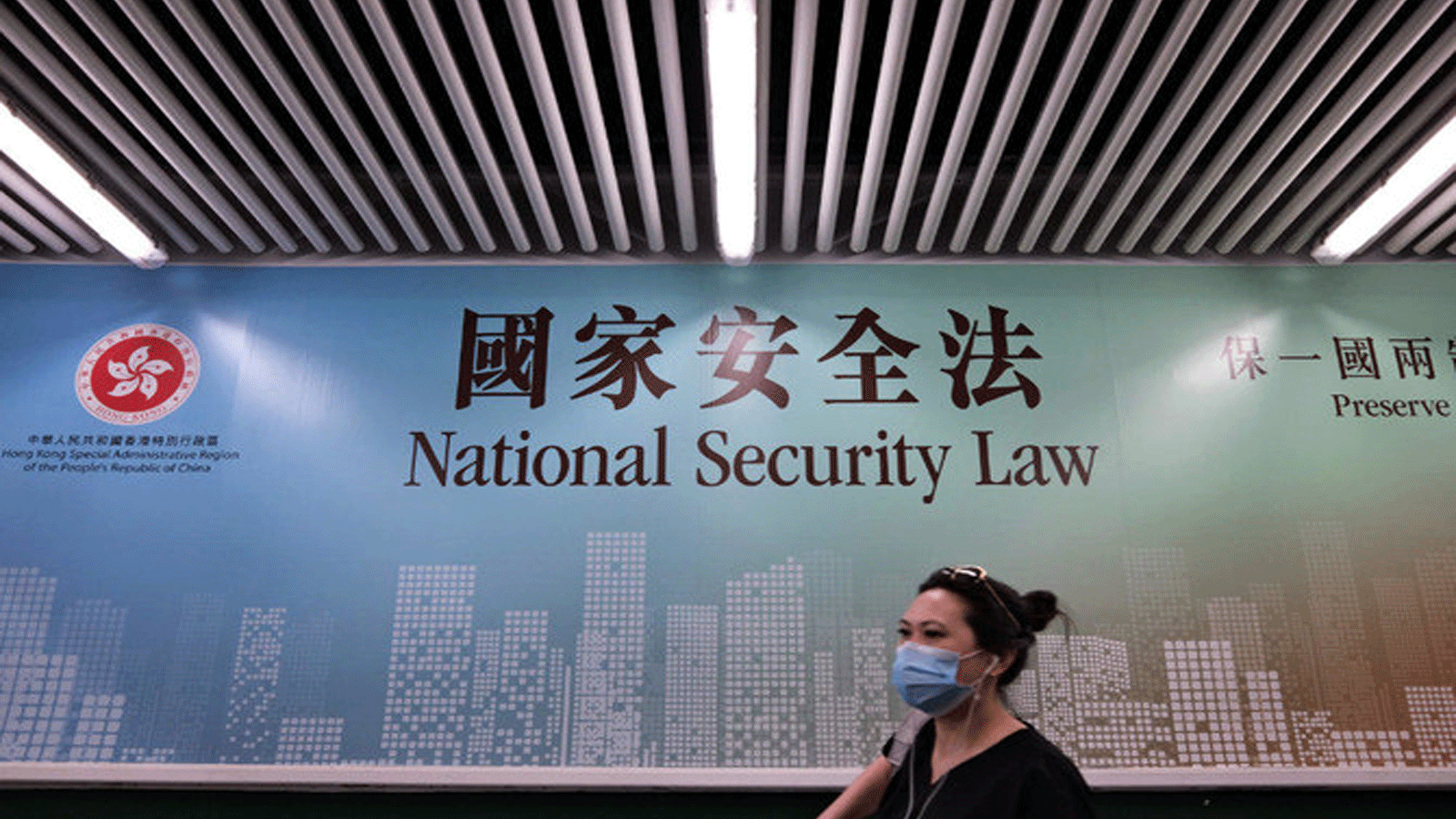 امرأة تمر بجانب ملصق لقانون الأمن القومي في هونغ كونغ