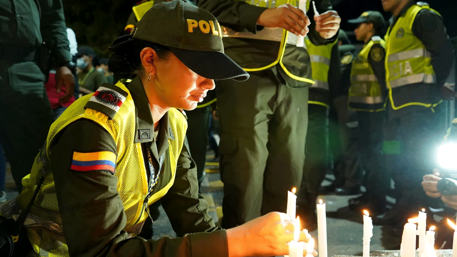 ضباط الشرطة الكولومبية يشاركون بإضاءة الشموع بعد هجوم بالمتفجرات أسفر عن مقتل ثمانية من زملائهم