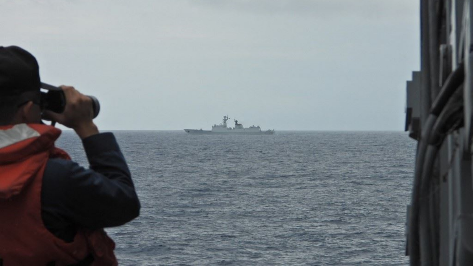 بحار من البحرية التايوانية يراقب سفينة حربية تابعة للبحرية الصينية