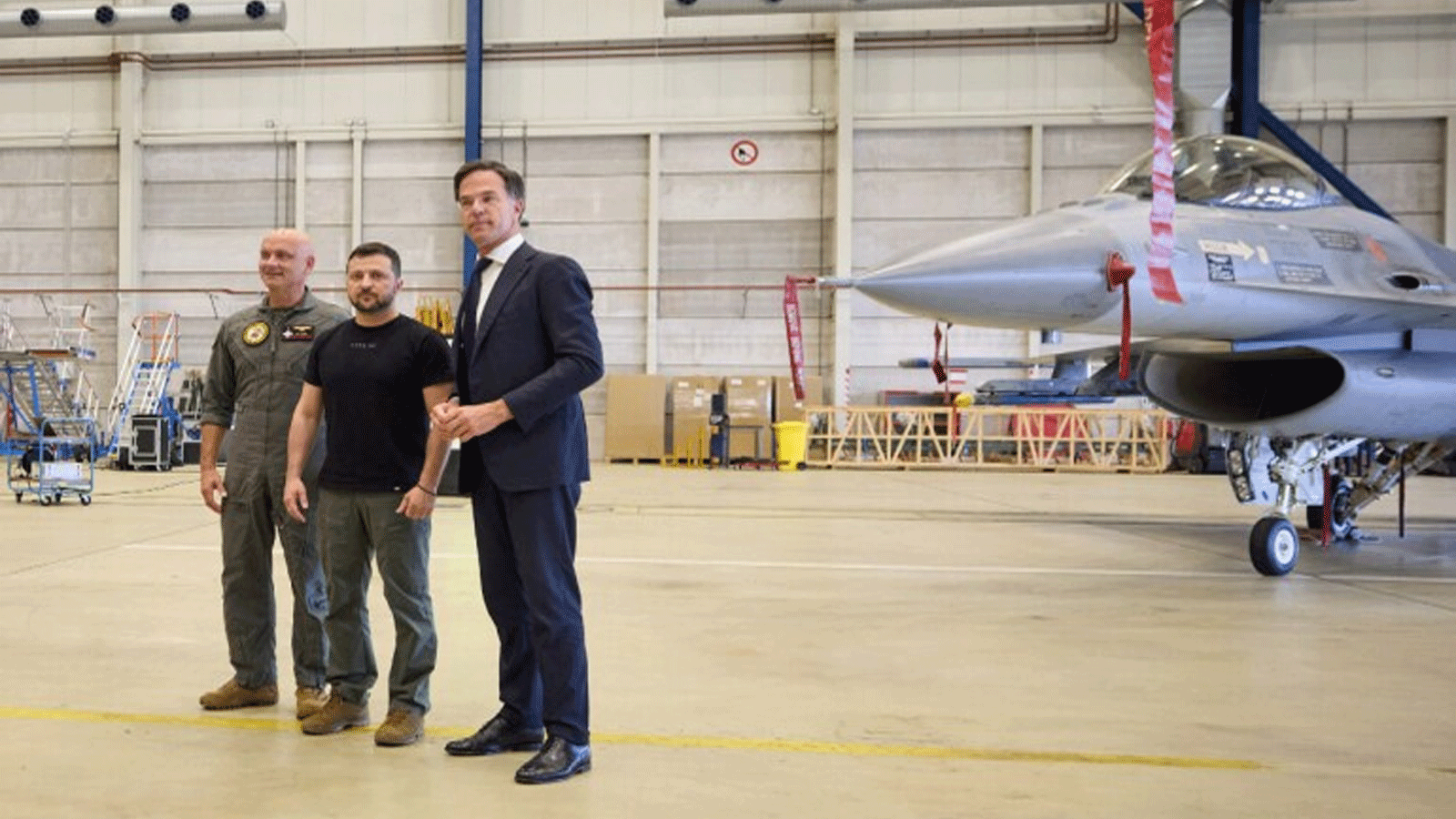 صورة التقطتها الخدمة الصحفية الرئاسية الأوكرانية ونشرتها في 20 أغسطس\آب 2023، تُظهر الرئيس الأوكراني فولوديمير زيلينسكي (وسط) ورئيس الوزراء الهولندي مارك روته (يمين) يقفان بجوار طائرة مقاتلة من طراز F-16 في حظيرة الطائرات في أيندهوفن العسكرية، القاعدة الجوية في أيندهوفن