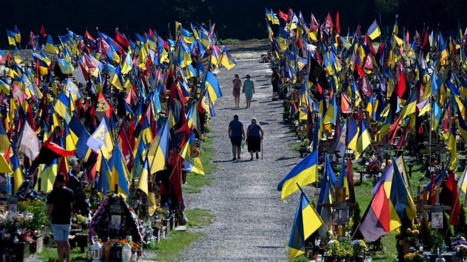 أشخاص يمشون في مقبرة ليتشاكيف في لفيف، احتراما للجنود الذين سقطوا في النضال من أجل استقلال أوكرانيا وسيادتها وسلامة أراضيها، في ذكرى المدافعين عن أوكرانيا 29 أغسطس 2023