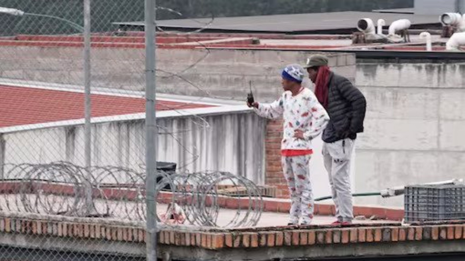 سجين يحمل جهاز اتصال لاسلكي يقف على سطح سجن توري في كوينكا، الإكوادور