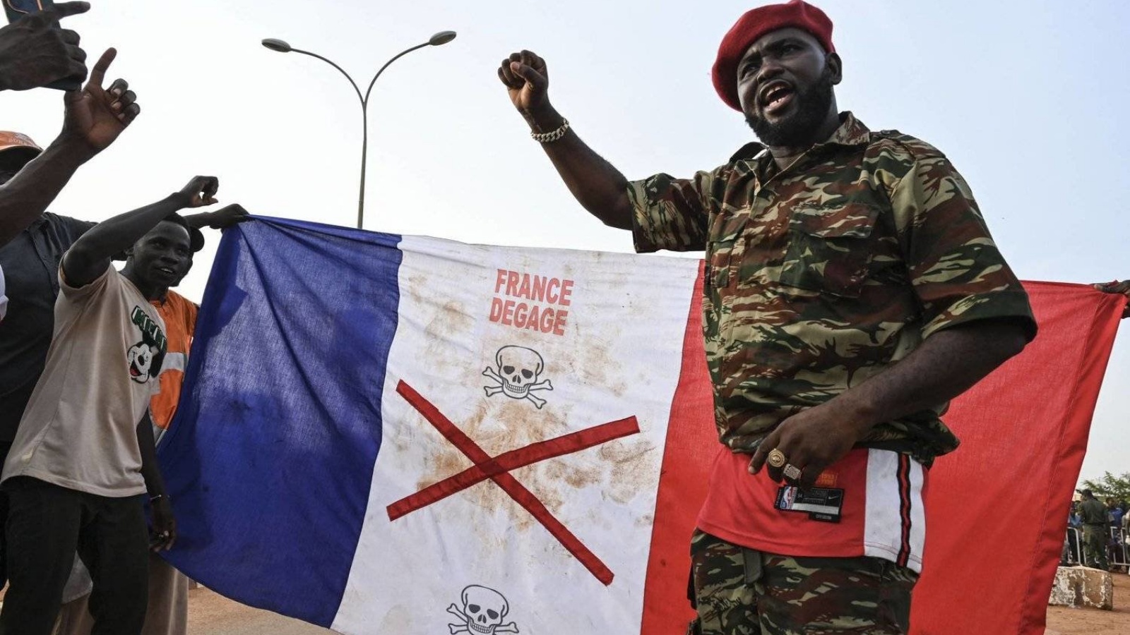 متظاهرون يحملون عَلم فرنسا أمام القاعدة الفرنسية في نيامي
