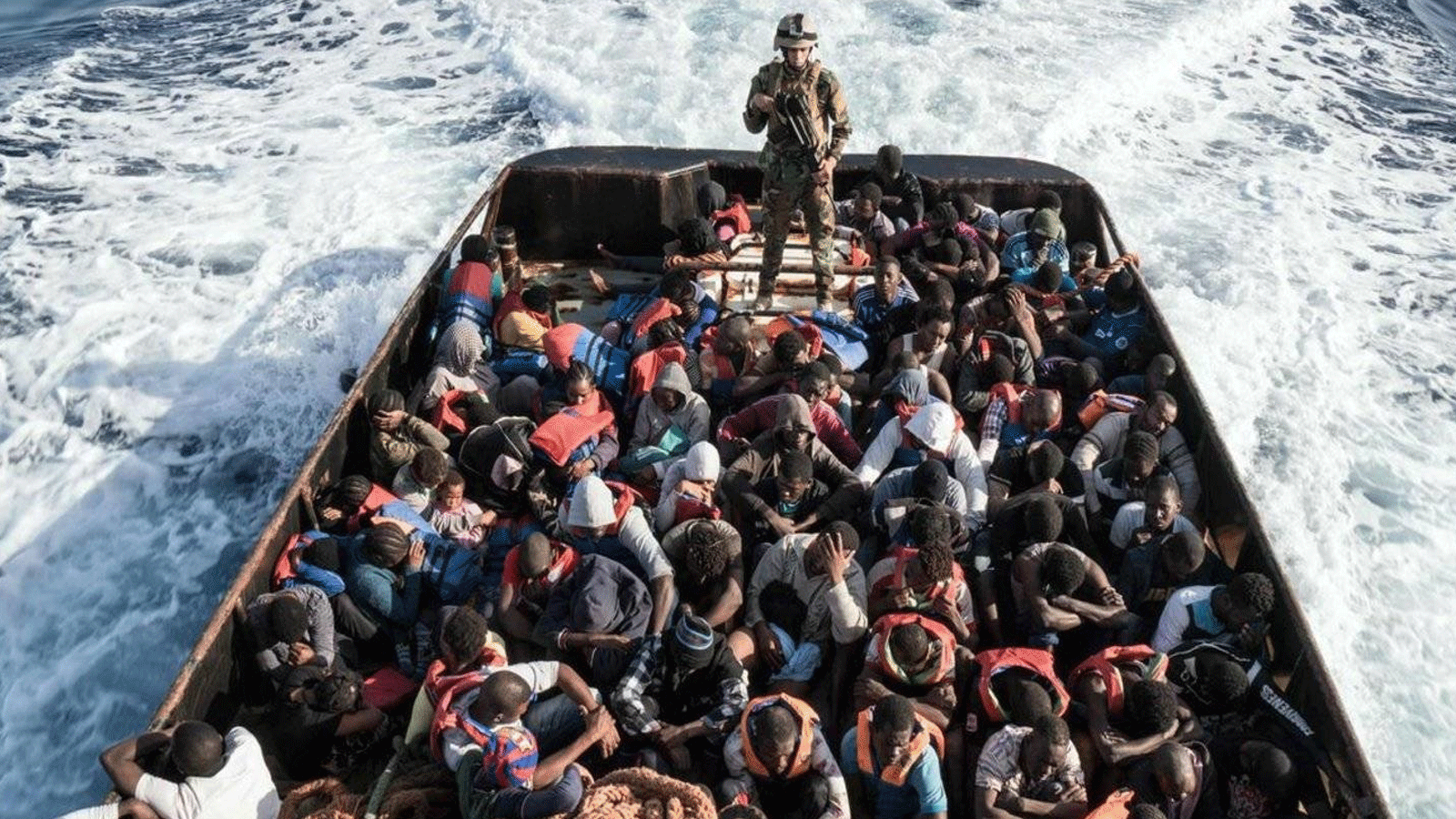 صورة أرشيفية لأحد أفراد خفر السواحل الليبي يقف على متن قارب أثناء عملية إنقاذ المهاجرين غير الشرعيين الذين يحاولون الوصول إلى أوروبا قبالة مدينة الزاوية الساحلية