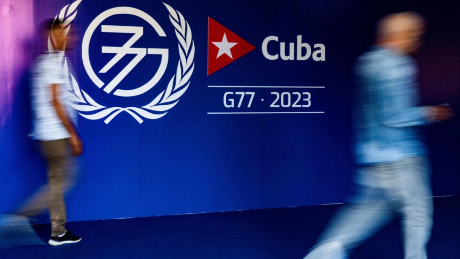 أشخاص يمرون من أمام لافتة تدل على قمة مجموعة77+الصين في هافانا بتاريخ 13 سبتمبر 2023