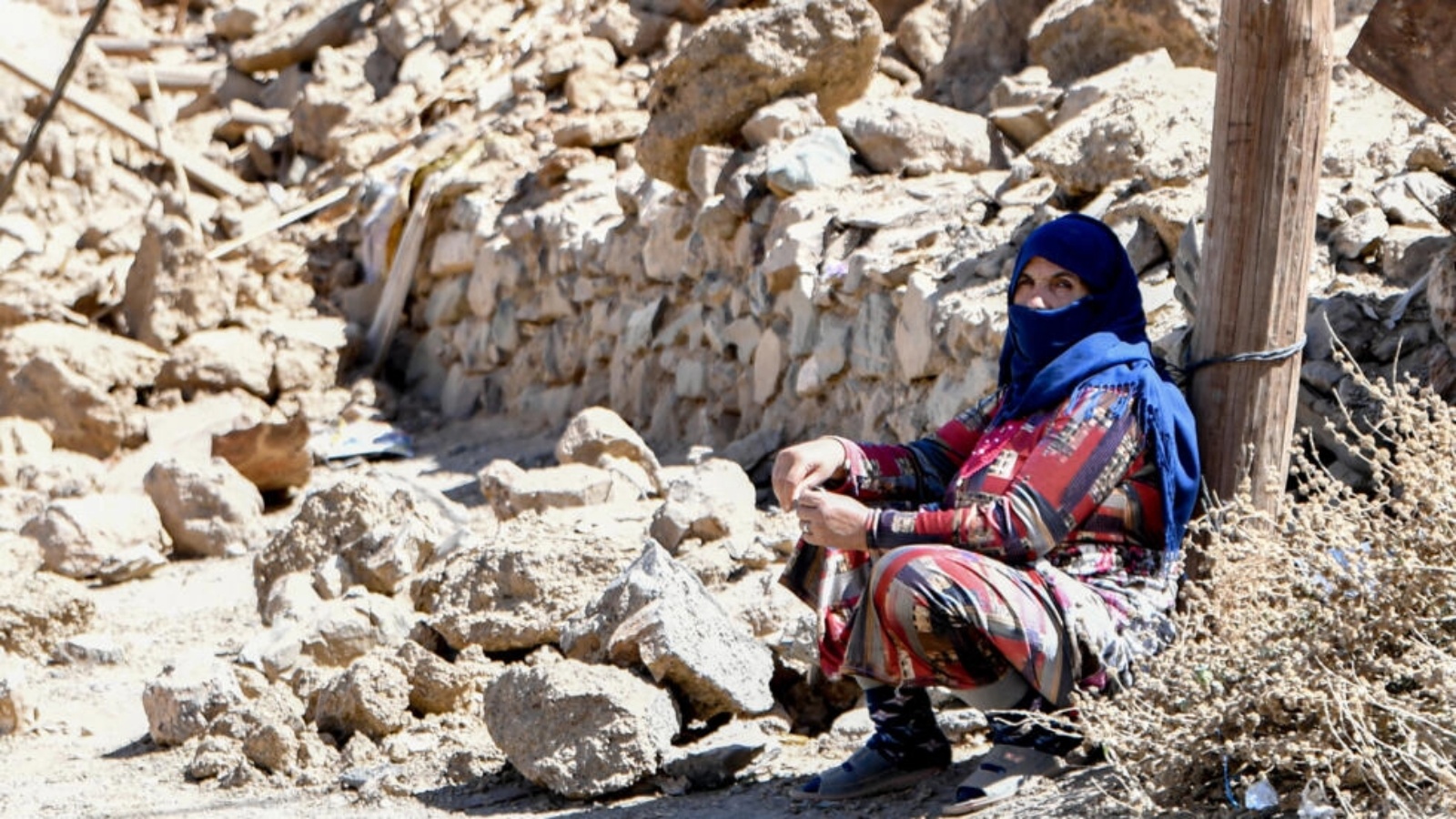 امرأة جالسة قرب حطام منزل دمره الزلزال في قرية أردوز في جبال الأطلس المغربية في 14 سبتمبر 2023