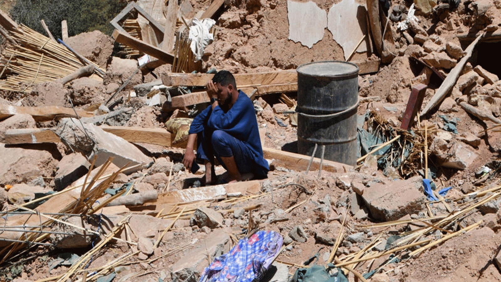 شاب يبكي فقدان أحبائه على أنقاض قرية تيخت القريبة من مركز الزلزال المدمر الذي ضرب المغرب بشكل كامل