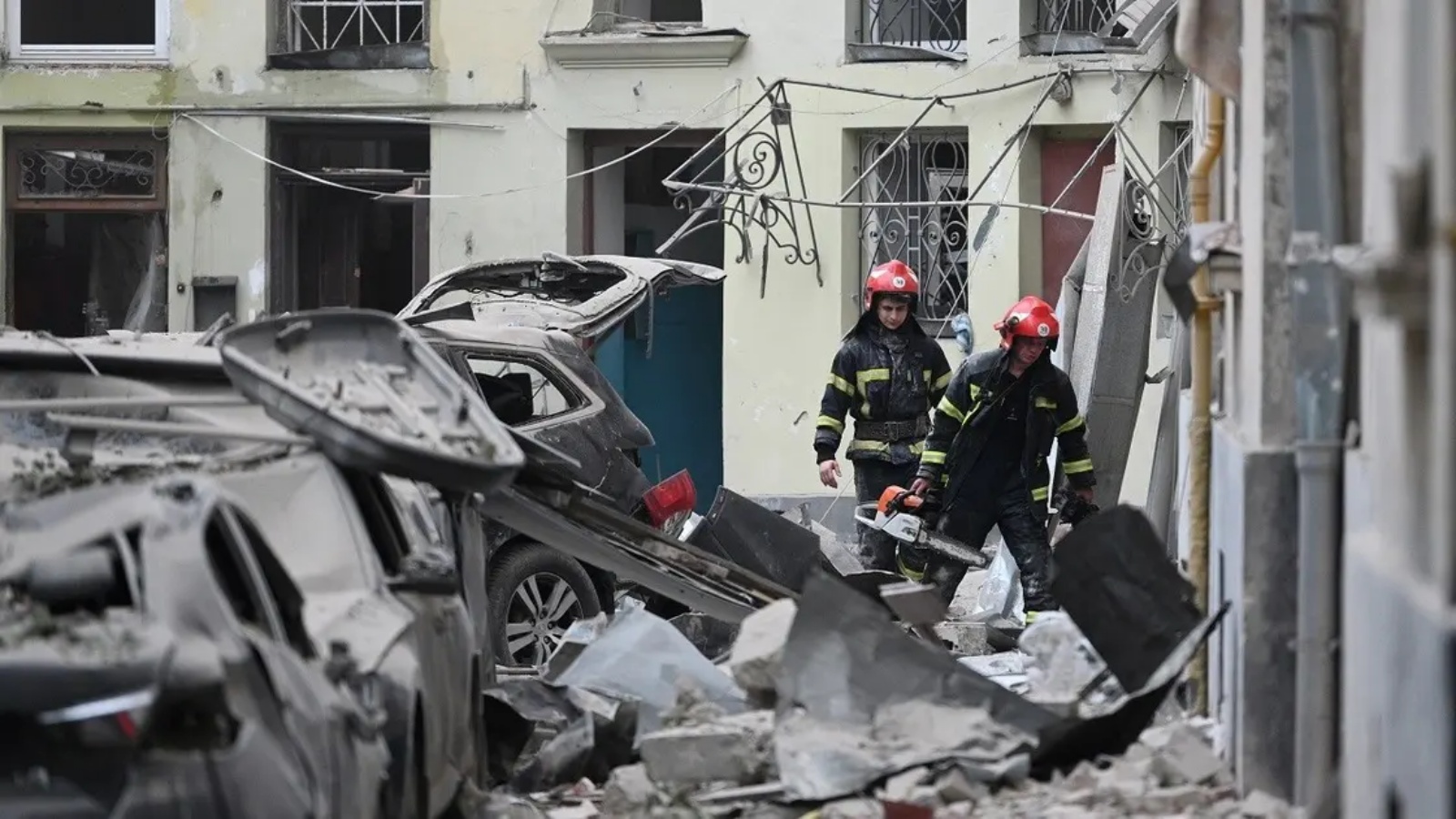 عمال إنقاذ يعملون في مبنى سكني دمر جزئيا جراء هجوم صاروخي في مدينة لفيف غرب أوكرانيا (أرشيفية)
