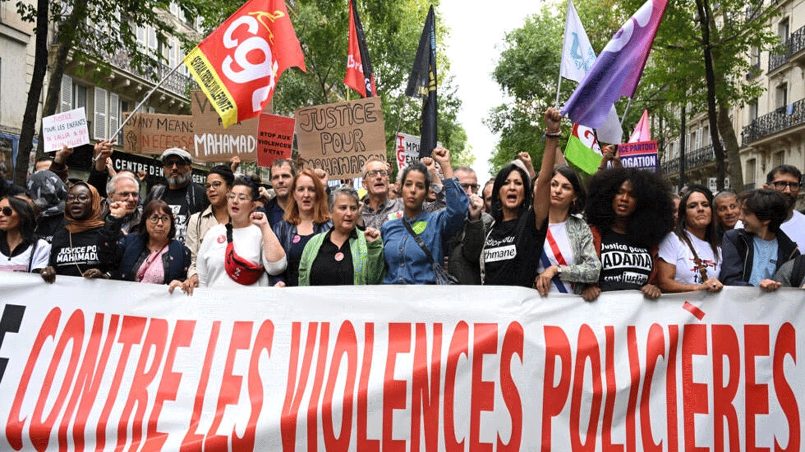 متظاهرون يحملون لافتة كتب عليها "ضد عنف الشرطة" خلال "مسيرة موحدة" ضد وحشية الشرطة دعت إليها المنظمات غير الحكومية والنقابات والأحزاب السياسية في باريس