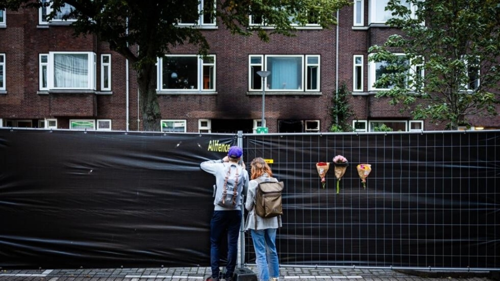 أشخاص يعلقون الزهور على سياج خارج مستشفى إيراسموس الجامعي في روتردام في 29 سبتمبر 2023، بعد يوم من مقتل امرأة وابنتها البالغة من العمر 14 عامًا ومحاضر جامعي بالرصاص 