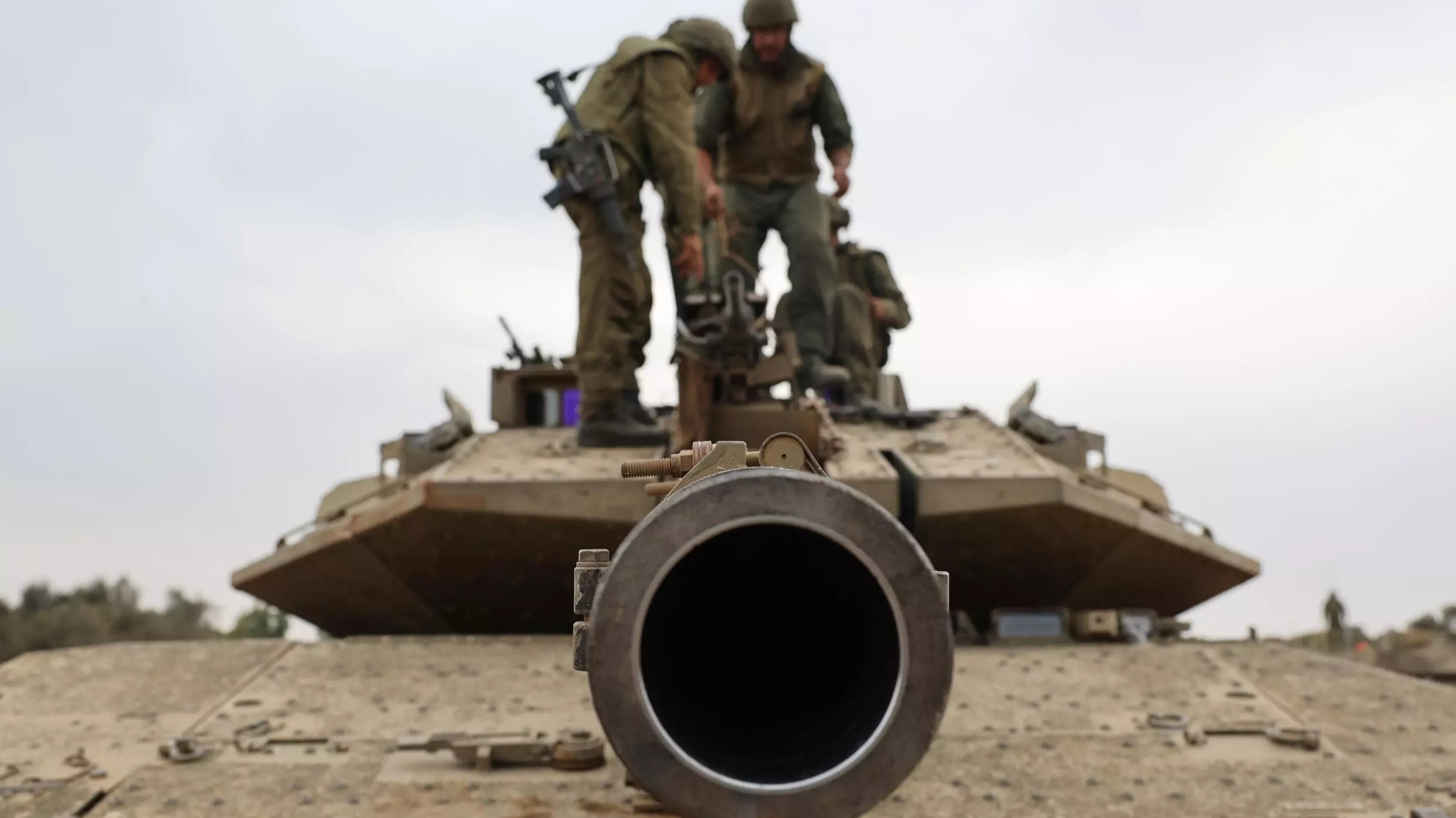 جنود إسرائيليون على دبابة ميركافا قرب الحدود مع غزة، حيث يستعد الفلسطينيون لما يخشى الكثيرون أن يكون هجوما بريا واسع النطاق