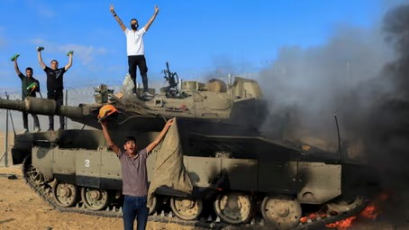 مقاتلون من حماس على متن دبابة إسرائيلية يوم السبت 