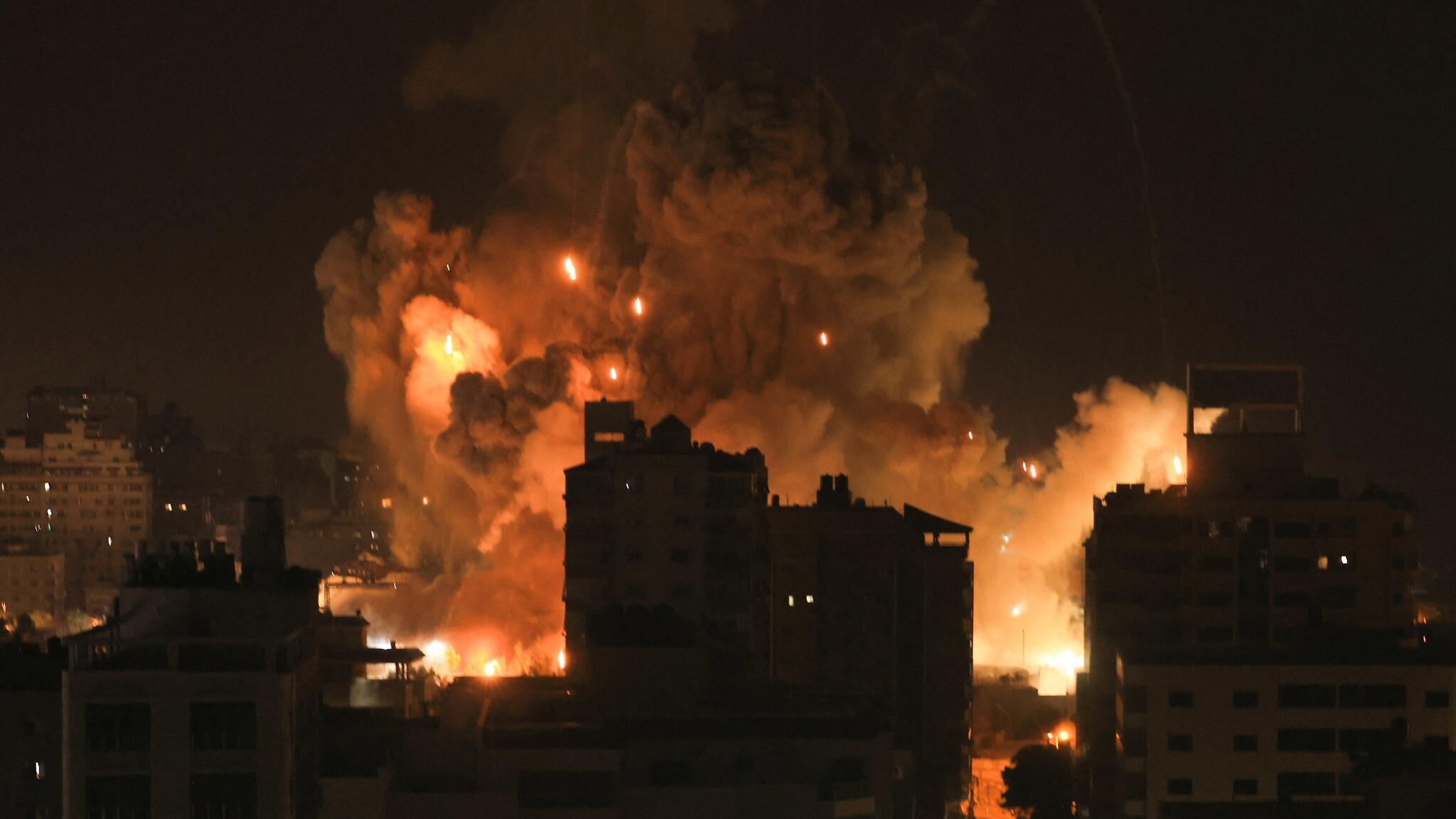 ألسنة اللهب تتصاعد فوق غزة ليل الثامن من أكتوبر 2023 جراء القصف الإسرائيلي