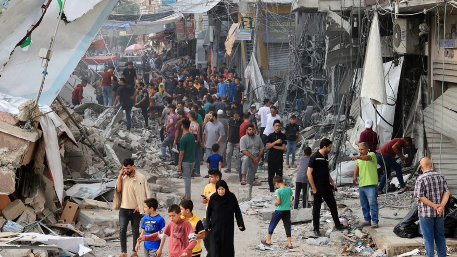 فلسطينيون يمشون وسط أنقاض مبنى مدمر في خان يونس من جراء قصف اسرائيلي جنوب قطاع غزة 10 أكتوبر 2023