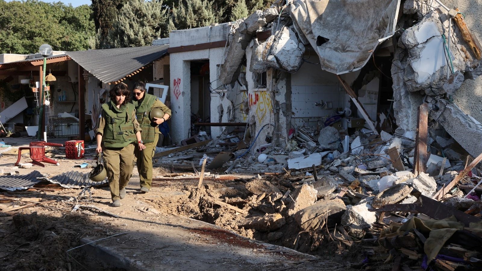 جنود من الجيش الإسرائيلي يقومون بدورية بالقرب من منازل متضررة في كيبوتس كفار عزة في جنوب إسرائيل 18 أكتوبر 2023