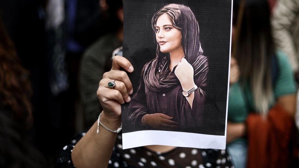 متظاهرة تحمل صورة الشابة مهسا أميني خلال تظاهرة دعم للحركة الاحتجاجية في إيران، في 23 أيلول/سبتمبر 2022 في بروكسل (ا ف ب)