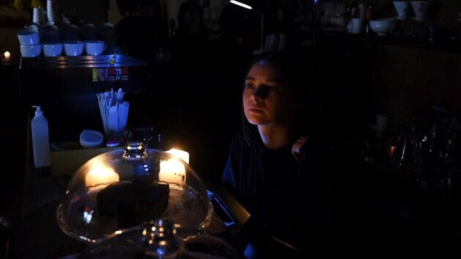 موظفة تعمل على ضوء الشموع في مقهى بدون كهرباء في مدينة لفيف بغرب أوكرانيا، 11 أكتوبر\ تشرين الأول 2022