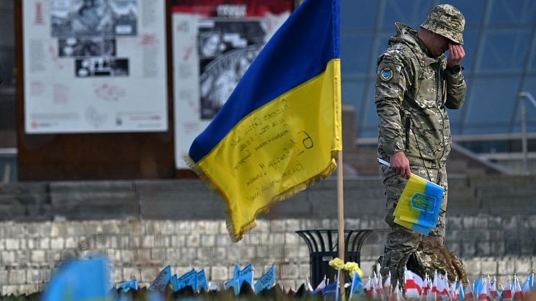 جندي يبكي بجوار العلم الأوكراني في نصب تذكاري مؤقت للجنود الذين سقطوا، في ميدان الاستقلال بكييف