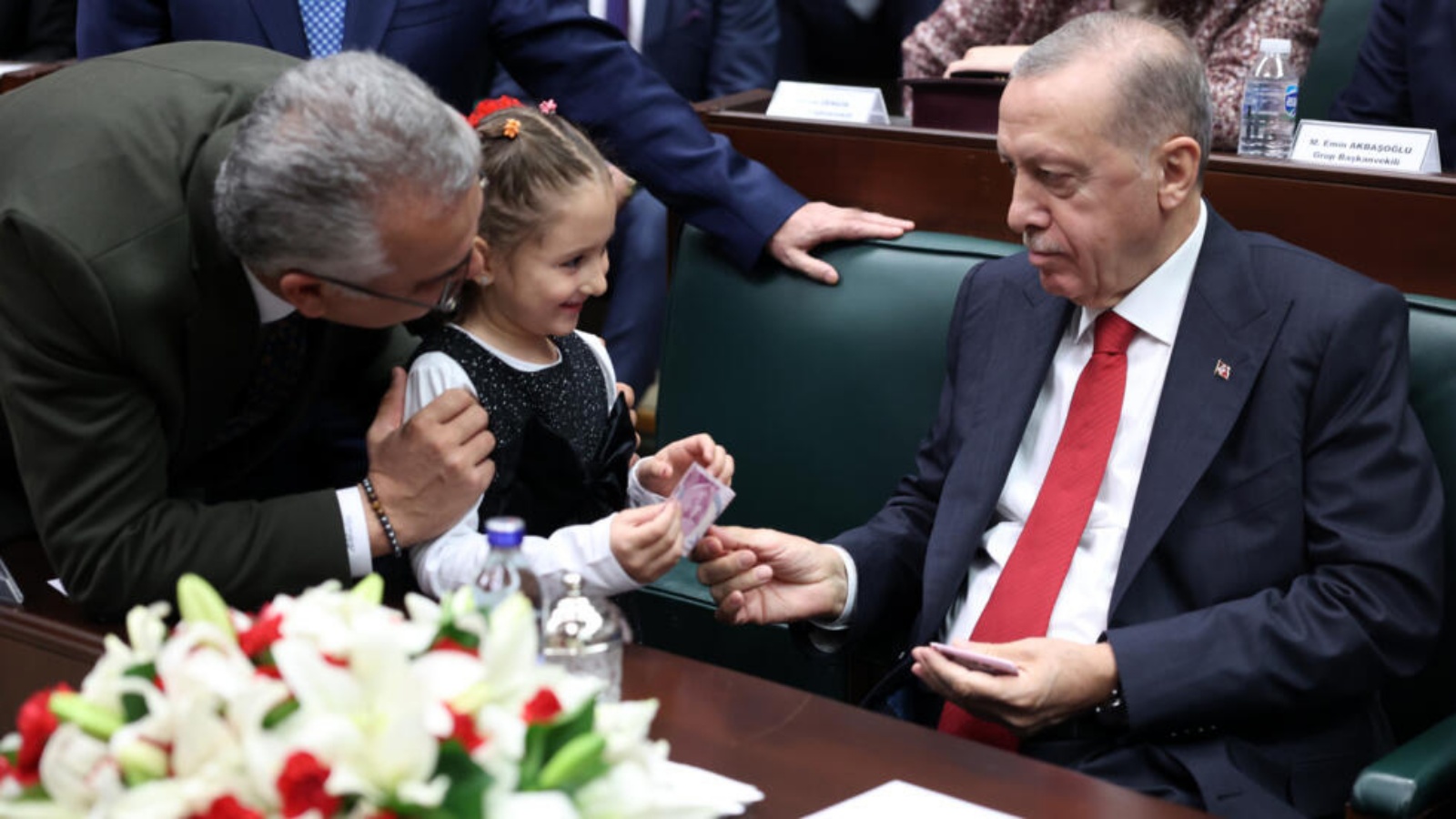 الرئيس التركي ورئيس حزب العدالة والتنمية رجب طيب أردوغان يعطي المال لفتاة جاءت إليه في اجتماع حزبه في البرلمان التركي في أنقرة في 15 نوفمبر 2023 
