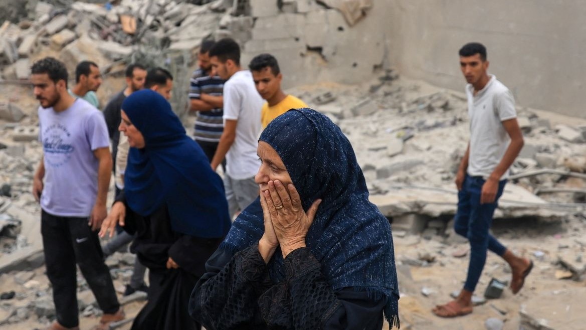 امرأة مذهولة وسط أنقاض مبنى مدمر بعد القصف الإسرائيلي في خان يونس