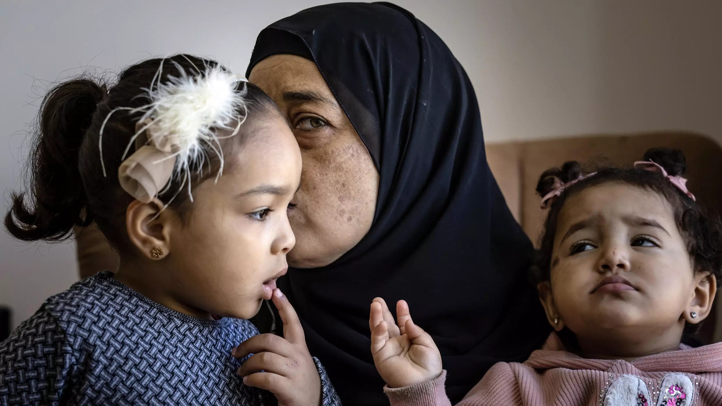 إيمان صباغ، والدة محمد صباغ الذي قتل خلال مواجهات مع الجيش الإسرائيلي في 9 تشرين الثاني/نوفمبر، تحتضن ابنتيه في منزل العائلة في جنين بالضفة الغربية المحتلة في 18 نوفمبر 2023