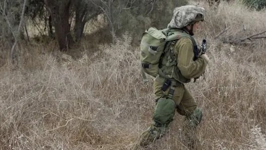 جندي إسرائيلي قرب الموقع الذي وقع فيه شاؤول آرون في قبضة الفلسطينيين في يوليو 2014