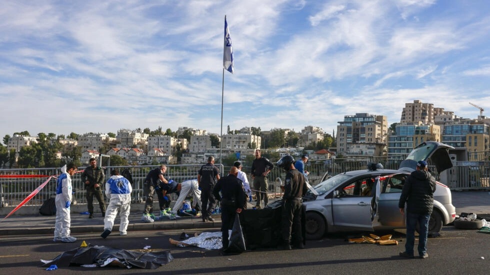 عناصر شرطة وأمن إسرائيليون يقفون قرب جثماني منفذا الهجوم في القدس الذي أسفر عن مقتل ثلاثة إسرائيليين في 30 نوفمبر 2023