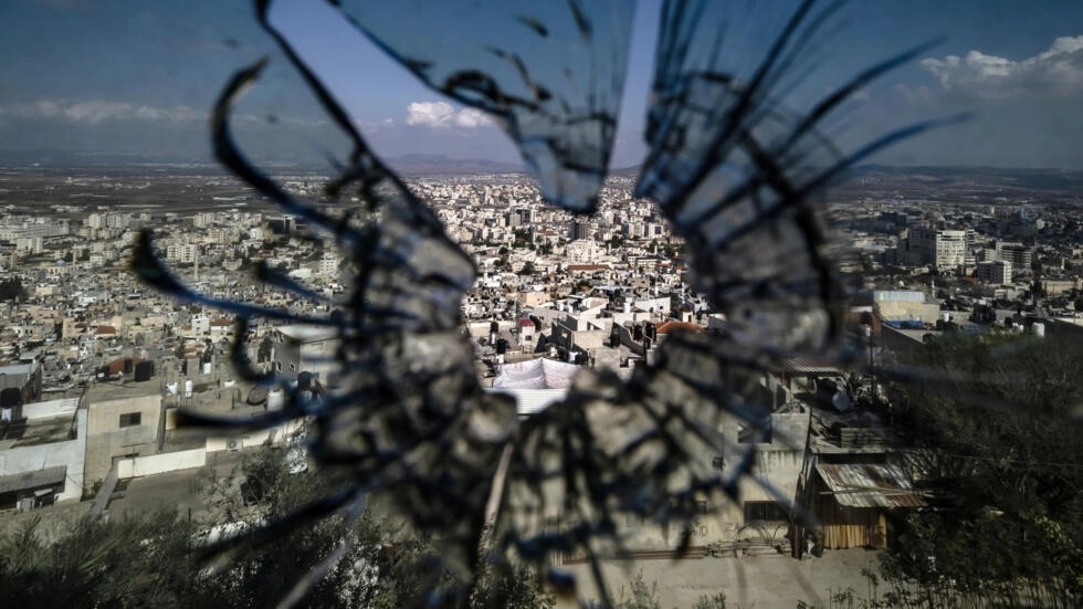 مشهد عام لمدينة جنين بالضفة الغربية، في صورة التقطت خلف زجاج منخور بالرصاص، في 8 نوفمبر 2023