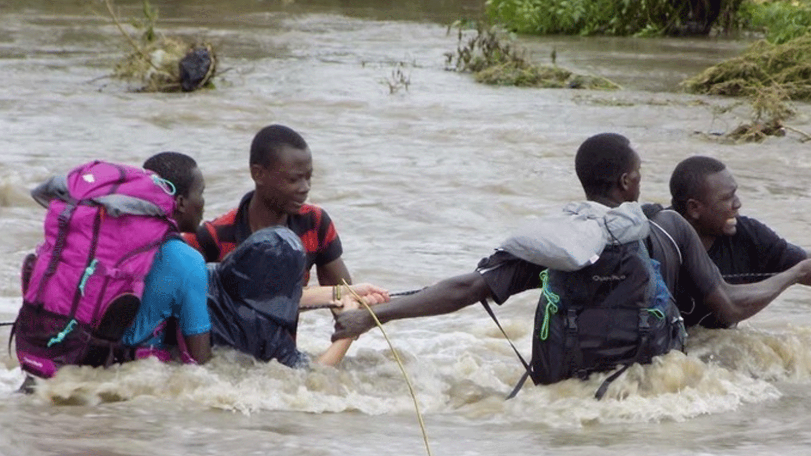  صورة أرشيفية لمواطنين يعبرون النهر بعد جسر نيما تونجاني في منطقة بانجاني شرق شمال تنزانيا حيث جرفت مياه الفيضانات الجسر بعد هطول أمطار غزيرة في جميع أنحاء البلاد(Xinhua)
