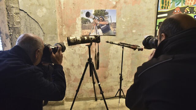 مصورون يلتقطون صورًا للكاميرا المتضررة لصحفي رويترز الراحل عصام عبد الله (صورة شخصية) خلال مؤتمر صحفي مشترك لـ هيومن رايتس ووتش ومنظمة العفو الدولية في بيروت في 7 ديسمبر 2023