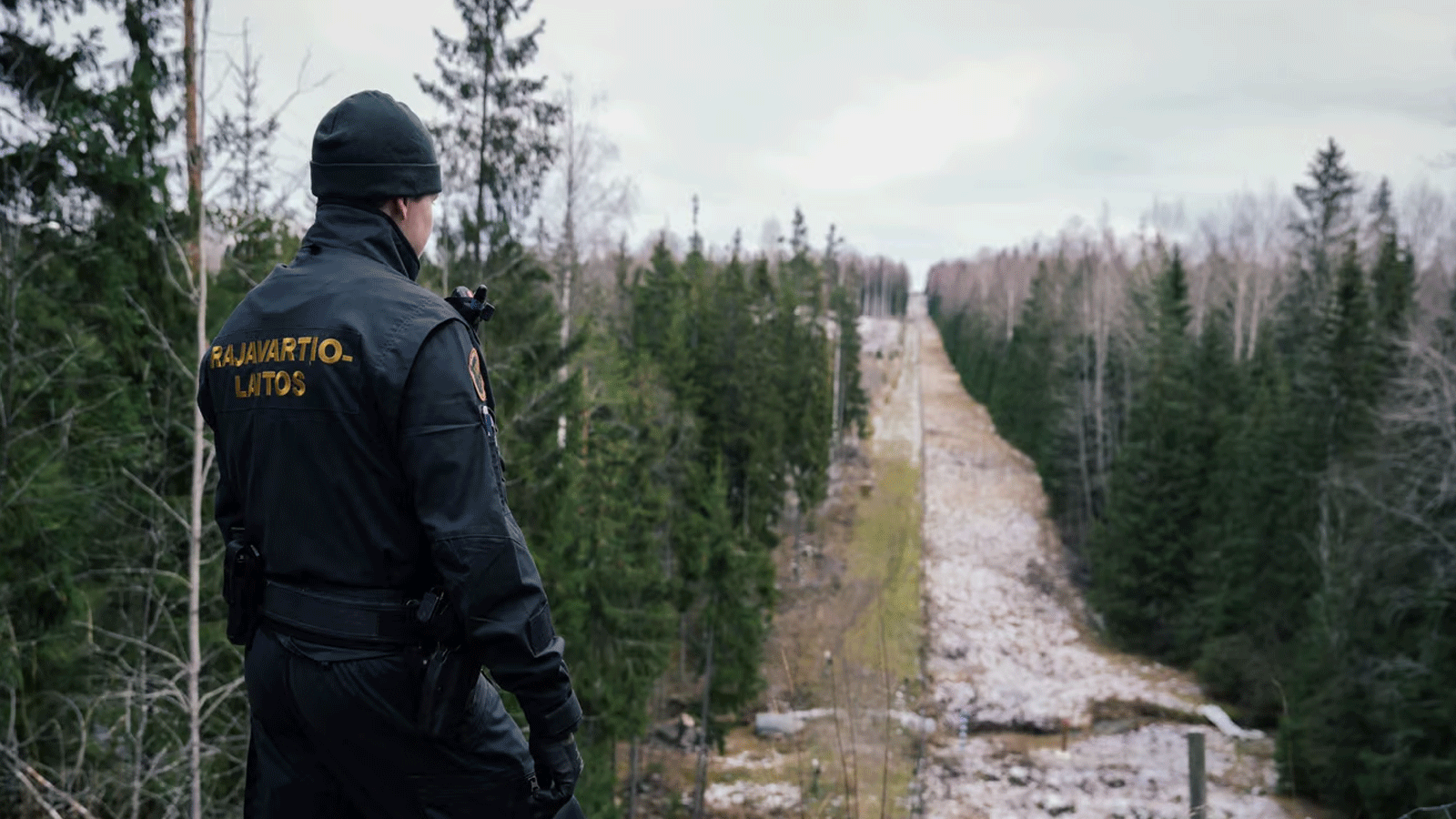 أحد حرس الحدود ينظر إلى الحد الفاصل بين فنلندا وروسيا، في إيماترا