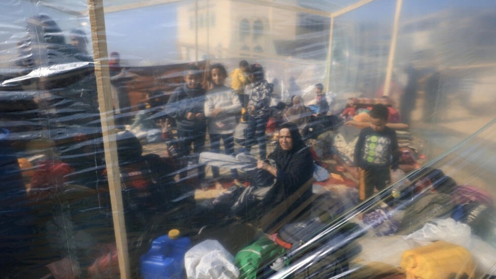 نازحون فلسطينيون تحت خيمة بلاستيكية في رفح في السادس من كانون الأول/ديسمبر 2023